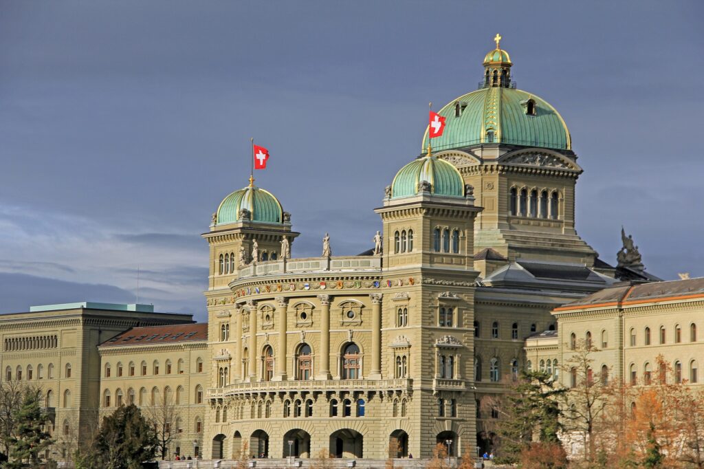 Image of the Federal Parliament Building with waving Isle of Man flags
